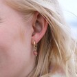 Close Up of Model Wearing Strawberry Quartz Stone Huggie Hoop Earrings in Gold