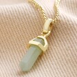 Green Aventurine Crystal Point Pendant Necklace in Gold on Beige Fabric