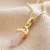 Rose Quartz Crystal Point Pendant Necklace in Gold on Beige Fabric