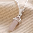 Rose Quartz Crystal Point Pendant Necklace in Silver on Beige Fabric