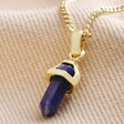 Sodalite Crystal Point Pendant Necklace in Gold on Beige Fabric