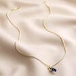 Sodalite Crystal Point Pendant Necklace in Gold Full Length on Beige Fabric