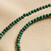 Tiny Green Malachite Necklace Close Up on Beige Material