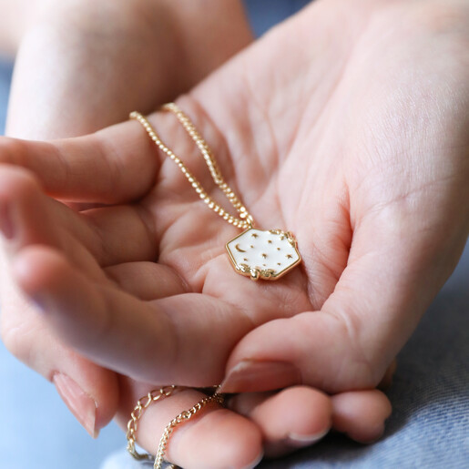 Model Holding White Enamel Celestial Bee Pendant Necklace in Gold in Palm of Hands