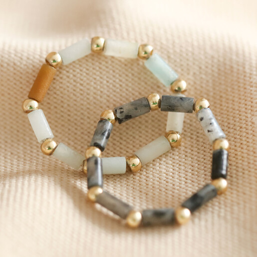 2 Semi-Precious Rings on Beige Fabric Set of 2 Semi-Precious Stone Beaded Rings in Grey and Green on Beige Fabric