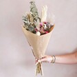 Model Holding Rustic Dried Flower Bouquet in Front of Pink Background