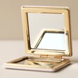 Open Metallic Live by the Sun Compact Mirror on Flat Surface