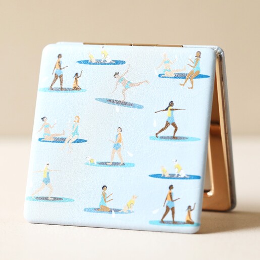Paddleboarding Compact Mirror Propped Upright on Beige Surface