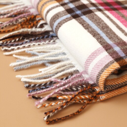 Close Up of Tassels on Colourful Tartan Winter Scarf Folded on Neutral Surface