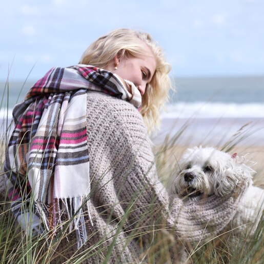 Model Wearing Colourful Tartan Winter Scarf Sitting Next to Small White Dog