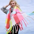 Model Wearing Neon Brights Check Winter Scarf with Tassels Flying Out Towards Camera