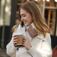 Model Wearing Neutral Striped Winter Scarf While Holding Coffee