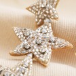 Close Up of My Doris Silver Star Beaded Drop Earrings Against Neutral Coloured Fabric