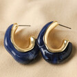Blue Molten Resin Organic Hoop Earrings in Gold on Beige Fabric
