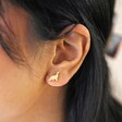 Close Up of Brushed Dinosaur Stud Earrings in Gold on Model
