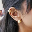Brushed Wide Gold Huggie Hoop Earrings in Gold on Model Close Up Wearing Matching Ear Cuff