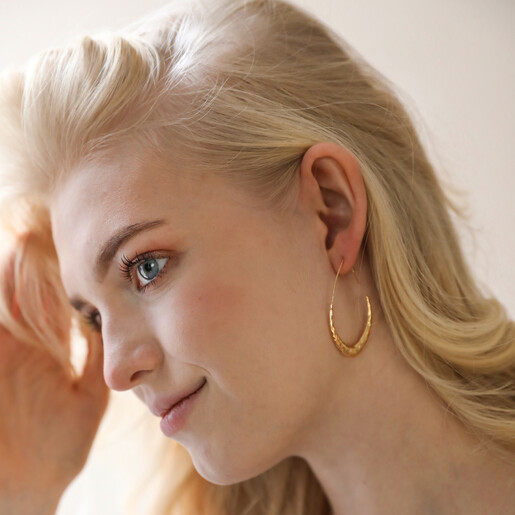 Model Wearing Hammered Teardrop Hoop Earrings in Gold Hand in Hair