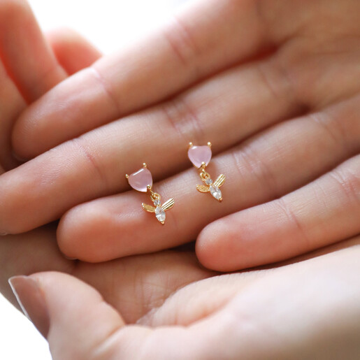 Model Holding Pink Crystal Heart and Bee Drop Earrings in Gold in Palm