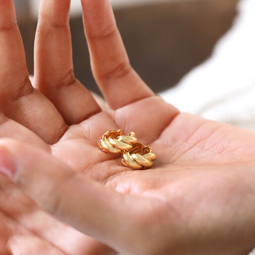 Model Holding Rope Huggie Hoop Earrings in Gold in Palm of Hand