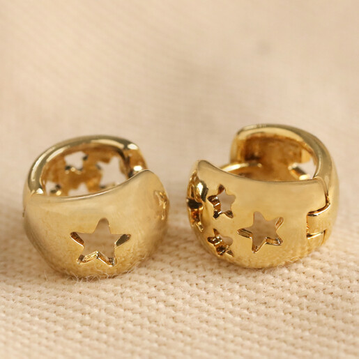 Tiny Star Cut-Out Huggie Hoop Earrings on Neutral Fabric