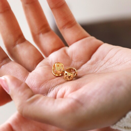 Model Holding Tiny Star Cut-Out Huggie Hoop Earrings
