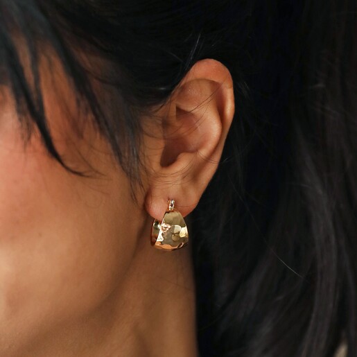 Close Up of Wide Hammered Hoop Earrings in Gold on Model