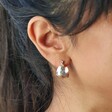 Close Up of Model Wearing Wide Hammered Hoop Earrings in Silver
