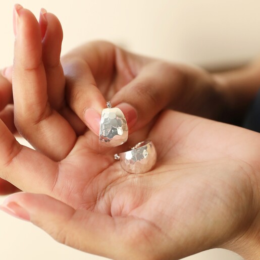 Wide Hammered Hoop Earrings in Silver in Model's Hand