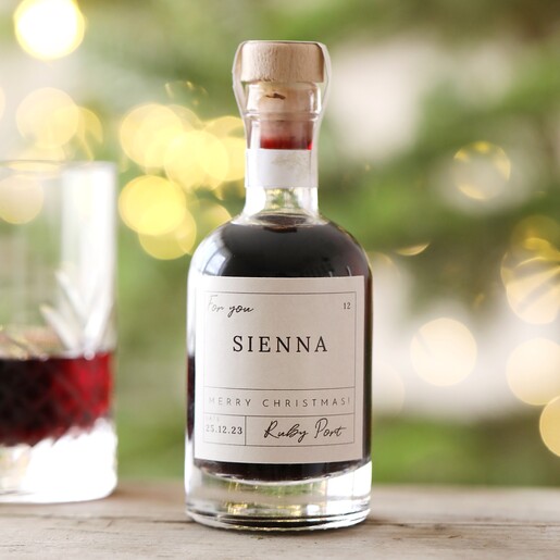 Ruby Personalised 100ml Merry Christmas Port on top of wooden counter with glass in background