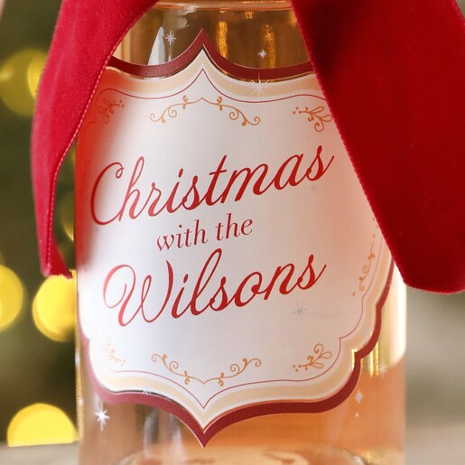 Close up of personalisation on Personalised 500ml Family Christmas Spiced Gin with Christmas tree in the background