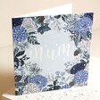 Amazing Mum Blue Floral Christmas Card standing on top of raised beige surface with fake snow