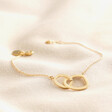 Organic Interlocking Hoops Bracelet in Gold laid on top of beige coloured fabric