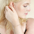 Model Touching Hair Wearing Pearl and Crystal Moon and Stars Bracelet in Gold