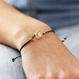 Close Up of Sun and Moon Cord Bracelet in Gold on Model's wrist
