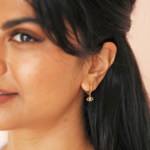 Crystal Evil Eye Huggie Hoop Earrings in Gold on Smiling Model