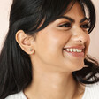 Model smiling wearing Green Crystal Stud Earrings in Gold