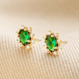 Green Crystal Stud Earrings in Gold on neutral coloured fabric