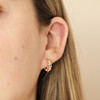 Close up of Irregular Crystal and Pearl Huggie Hoop Earrings in Gold on model