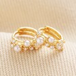 Close up of Irregular Pearl and Crystal Huggie Hoop Earrings in Gold