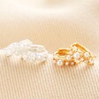 Irregular Pearl and Crystal Huggie Hoop Earrings in Silver and gold on beige fabric