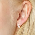 Close up of model wearing the Irregular Pearl and Crystal Huggie Hoop Earrings in Silver