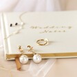 Large Mismatched Crystal Star and Moon Pearl Drop Earrings on Linen Notebook