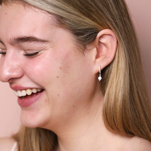 Opal Diamond Huggie Hoop Earrings in Silver on model in front of neutral coloured backdrop