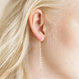 Close up of Model Wearing Thread Through Crystal and Pearl Chain Earrings in Gold