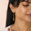 Thread Through Star and Pearl Chain Earrings in Gold on Model Smiling and Looking to Side