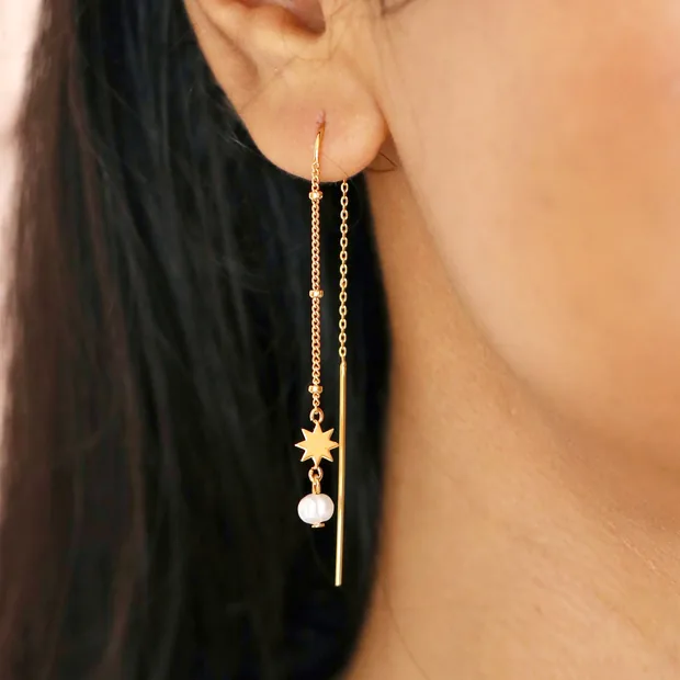 Close Up on Model Close Up of Thread Through Star and Pearl Chain Earrings in Gold on Model