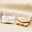 Envelope Locket Necklace in Silver with gold version on top of cream-coloured fabric