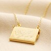 Back of Envelope Locket Necklace in Gold on top of beige coloured fabric
