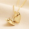 Heart Locket Necklace in Gold open against beige fabric