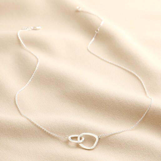 Organic Interlocking Hoops Necklace in Silver on top of beige coloured fabric